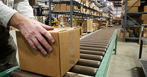 WMS vs ERP: Person working in warehouse with box of factory line